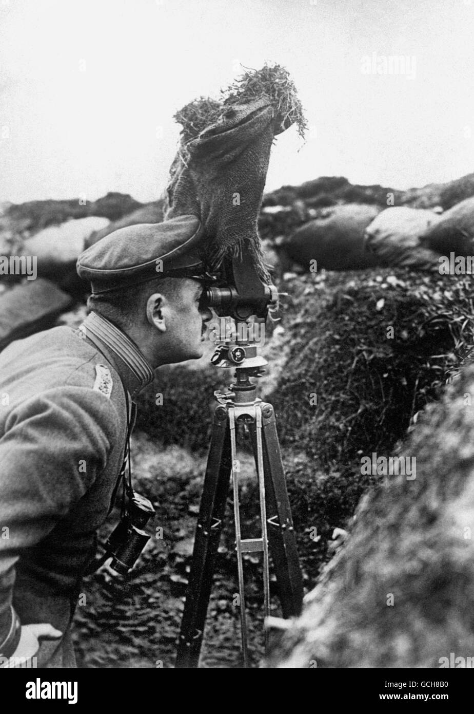 A German Army officer taking observations from a trench by means of a pair of periscope binoculars screened with sacking. Stock Photo