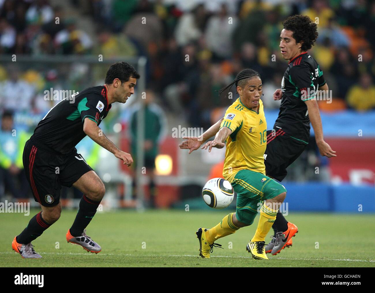 Soccer - 2010 FIFA World Cup South Africa - Group A - South Africa v Mexico - Soccer City Stadium. Mexico's Rafael Marquez (left) and Andres Guardado (right) battle for the ball with South Africa's Steven Pienaar (center) Stock Photo