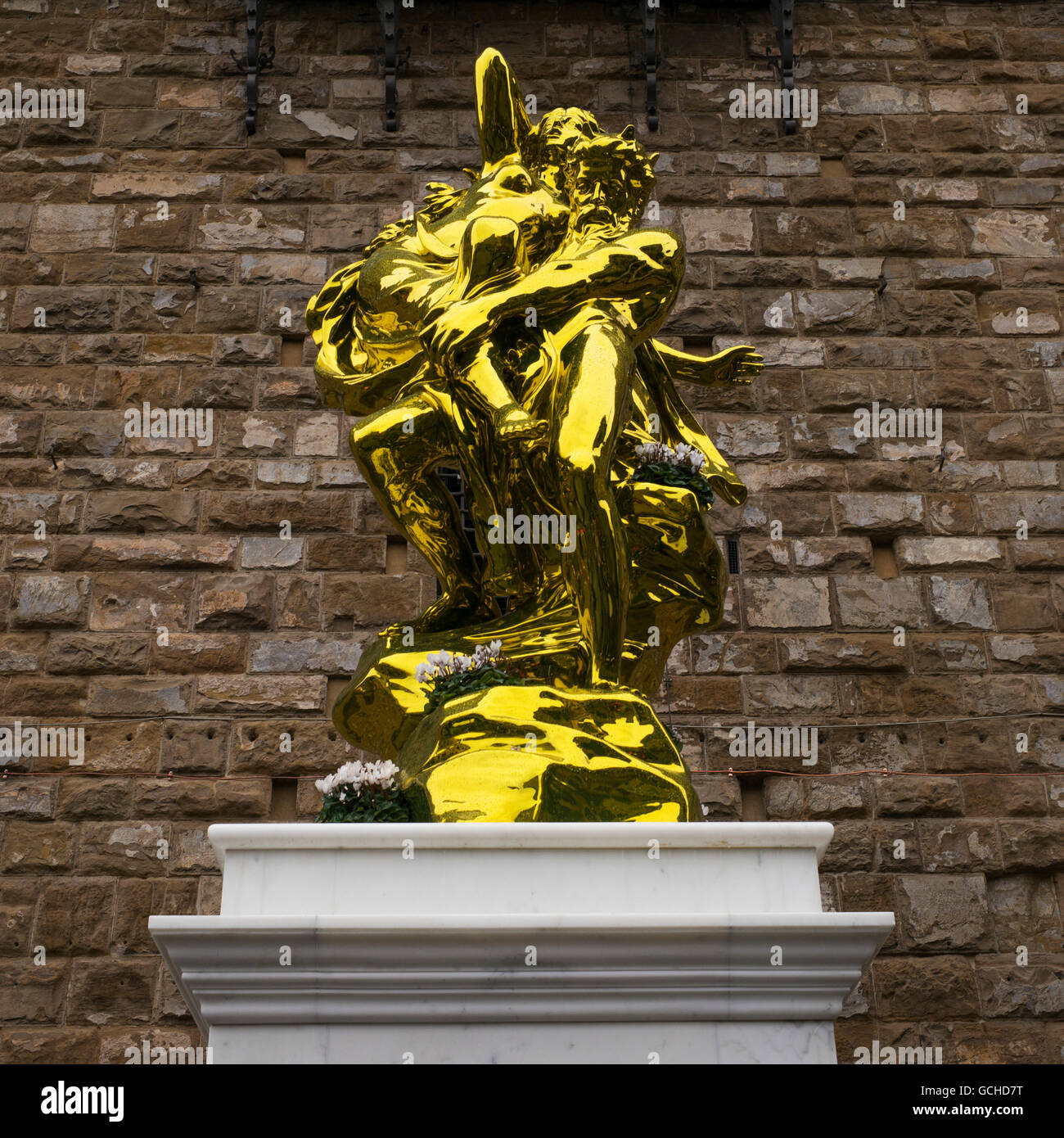 Gold statue against a stone wall in Piazza della Signoria; Florence, Italy Stock Photo