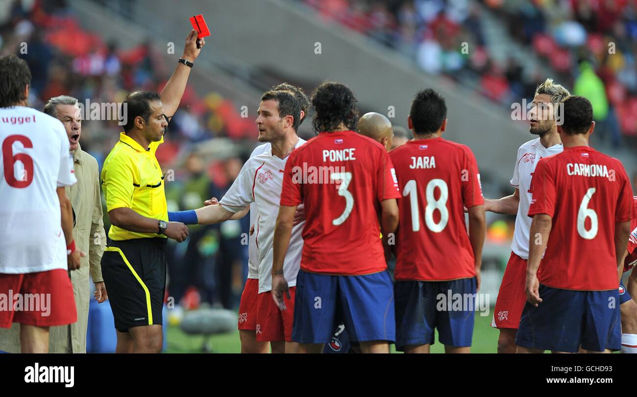 Switzerland coach Ottmar Hitzfeld (left) shouts as referee Khalil Al Ghamdi shows Valon Behrami (far right) the red card Stock Photo