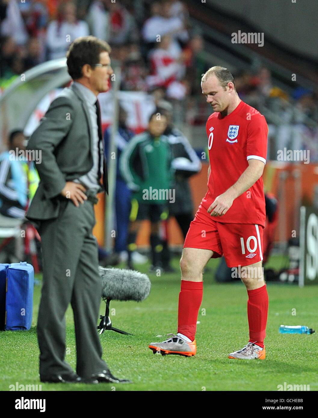 Soccer - 2010 FIFA World Cup South Africa - Group C - Slovenia v England - Nelson Mandela Bay Stadium. England's Wayne Rooney (right) walks past manager Fabio Capello (left) dejected as he is substituted Stock Photo