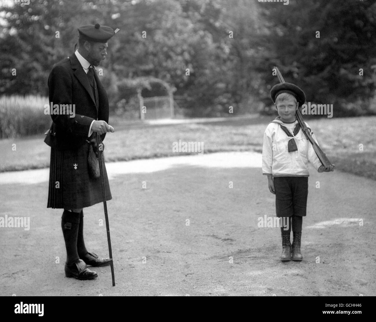 KING GEORGE V SUPERVISES HIS YOUNGEST SON, PRINCE JOHN, AS HE DRILLS. c1911. Stock Photo