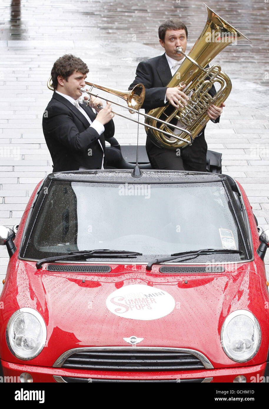 Royal Scottish National Orchestra (RSNO) Principal Trombone player Davur Juul Magnussen and Principal Tube John Whitener perform out of a convertible Mini on Buchanan Street in Glasgow to promote RSNO summer pops concerts. Stock Photo