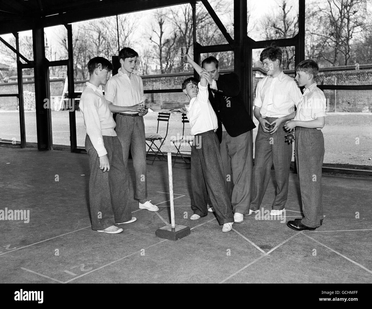 Alec Thompson of Middlesex County CC gives bowling instruction to C. Hunt. Looking on are RG Newman (Eton), RSD Frank (Uppingham), AJB Egremont-Lee (Charterhouse) and M Barty-King (Lockerspark Stock Photo