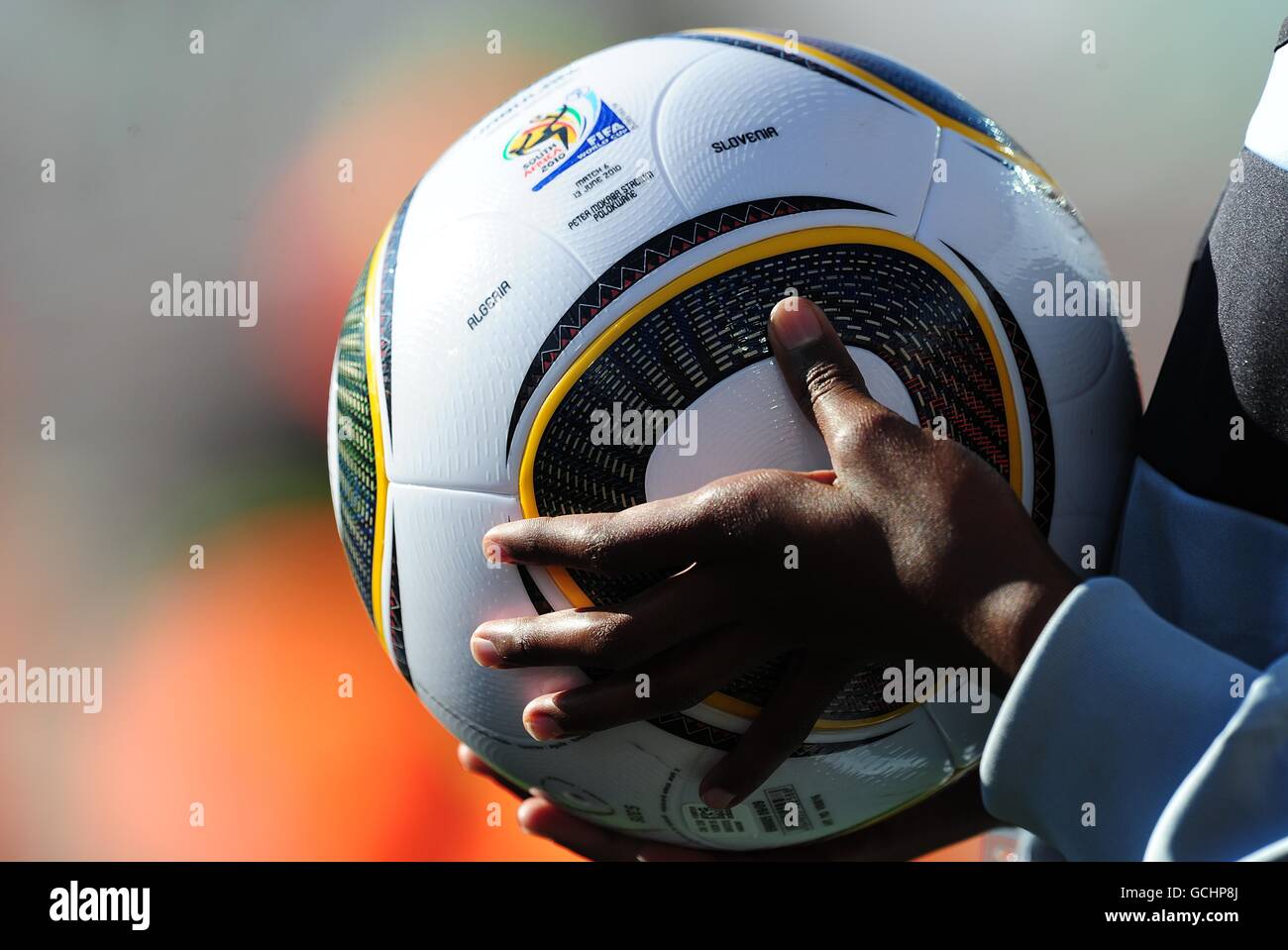 A ball boy holds a Adidas Jabulani match ball on the touchline Stock Photo