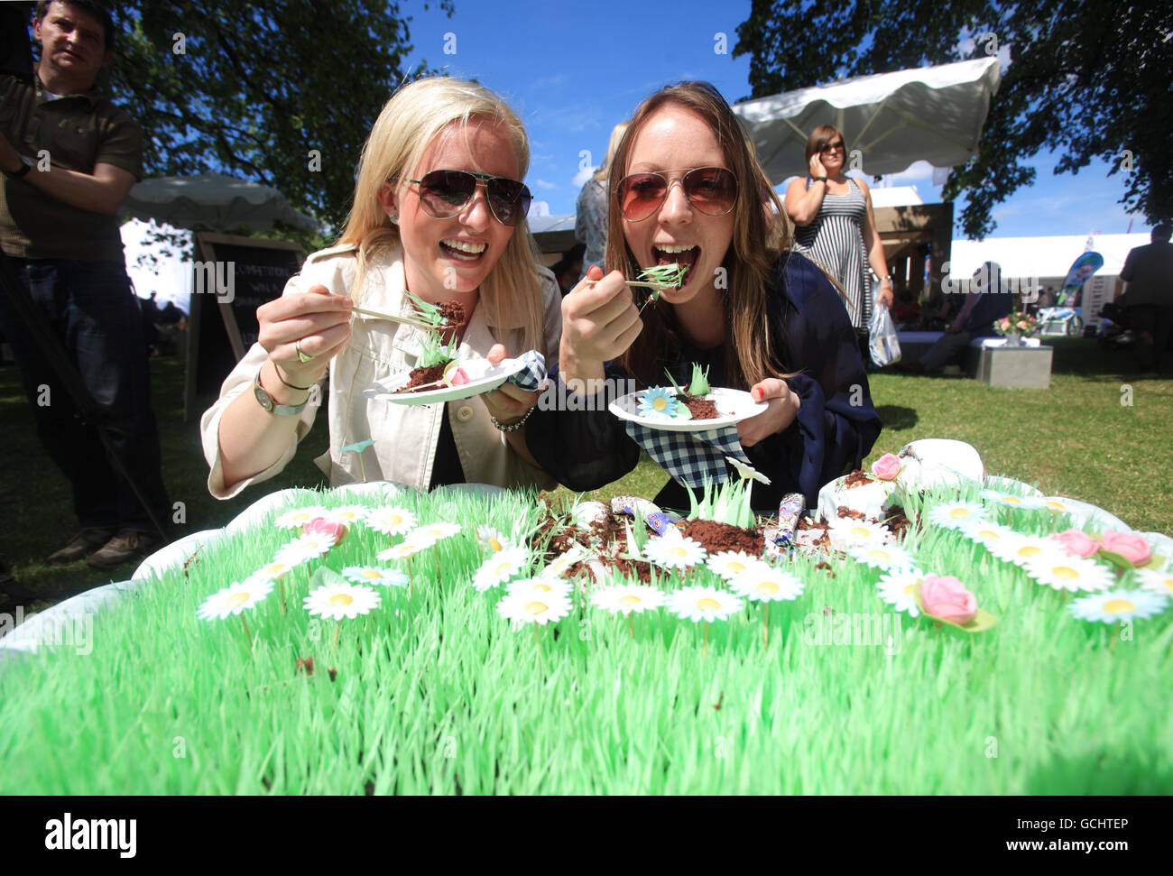 Rose Pennington (left) and Jessica Law sample some edible grass during the Taste of London food festival, in Regents Park, central London. Stock Photo