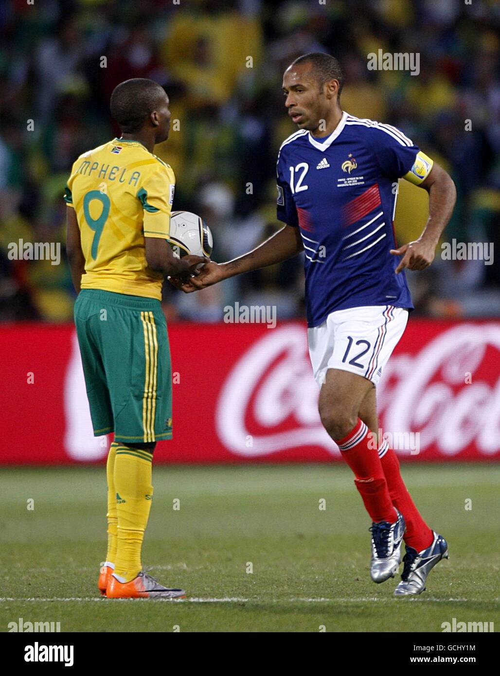 France's Thierry Henry (right) hands the ball to South Africa's Katlego Mphela (left) to restart the game after France score their only goal of the game Stock Photo
