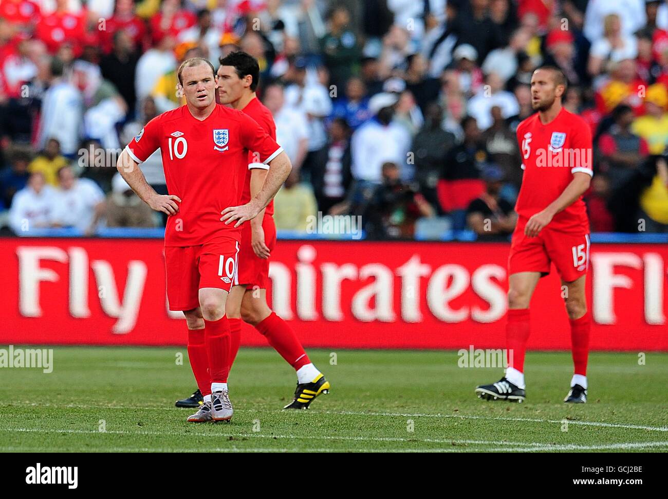 England's Wayne Rooney (left), Gareth Barry and Matthew Upson (right) stand dejected after they concede the opening goal of the game Stock Photo