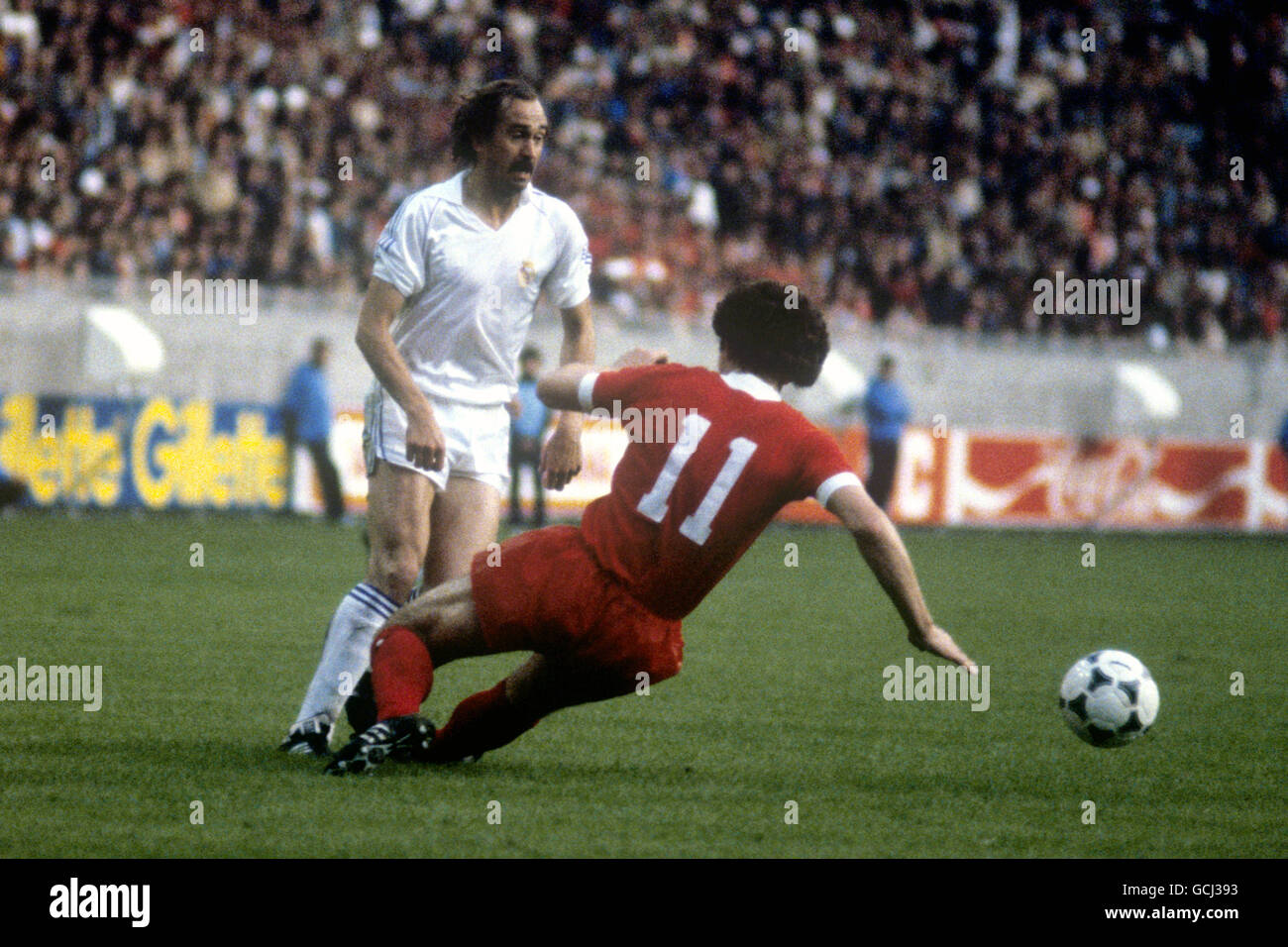 Liverpool's Graeme Souness slides in on Real Madrid's Uli Stielike despite the ball having already gone Stock Photo