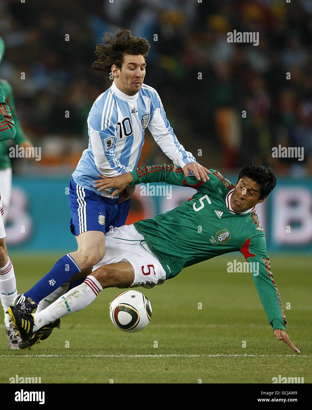 Soccer - 2010 FIFA World Cup South Africa - Round Of 16 - Argentina v Mexico - Soccer City Stadium. Argentina's Leo Messi and Mexico's Ricardo Osorio (right) battle for the ball Stock Photo