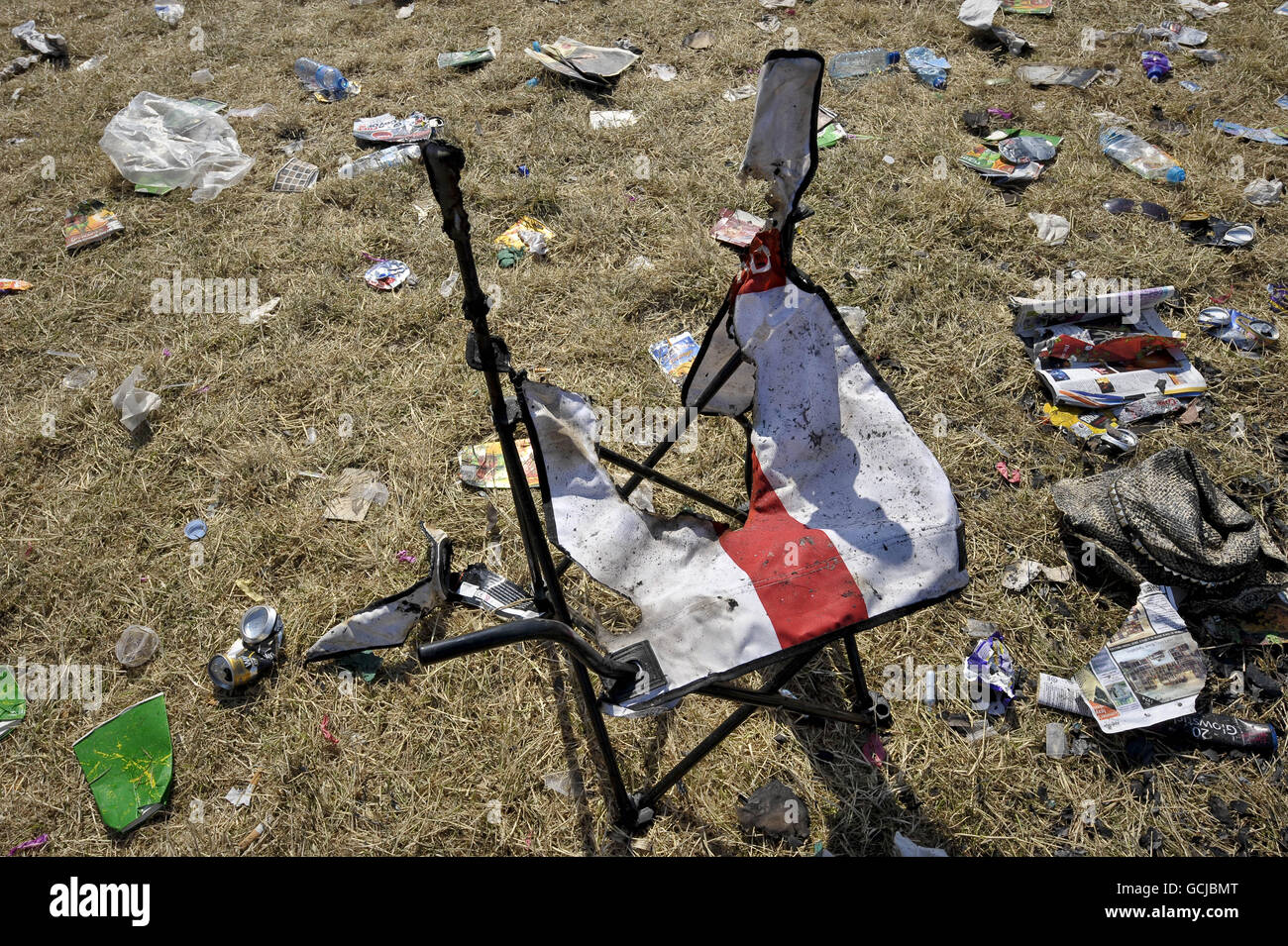 A burnt camping chair left behind as the clean-up operation begins after the Glastonbury Festival at Worthy farm, Somerset. Stock Photo
