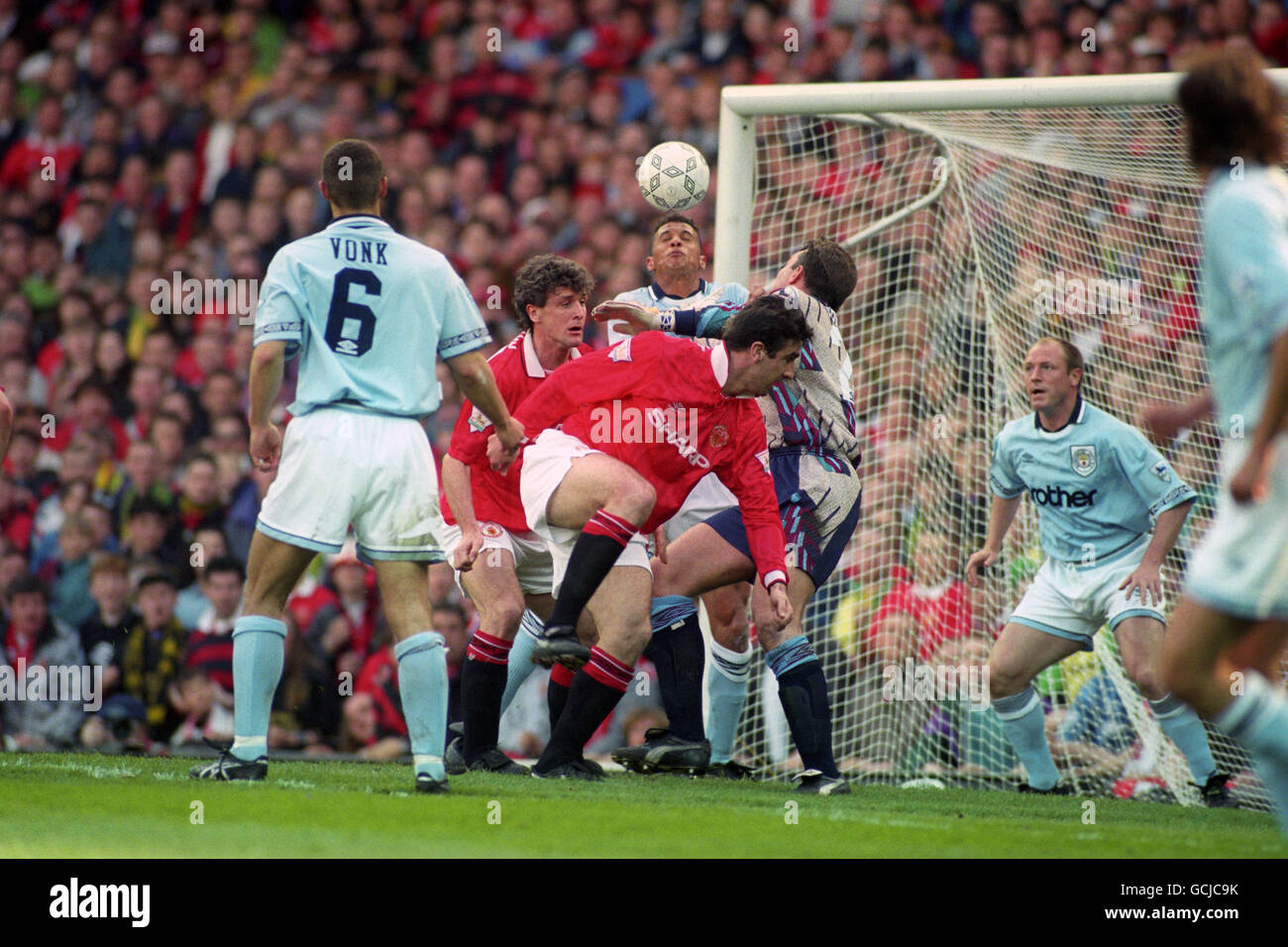 Manchester City defender Keith Curle heads the ball away from Manchester United strikers Mark Hughes and Eric Cantona. Stock Photo