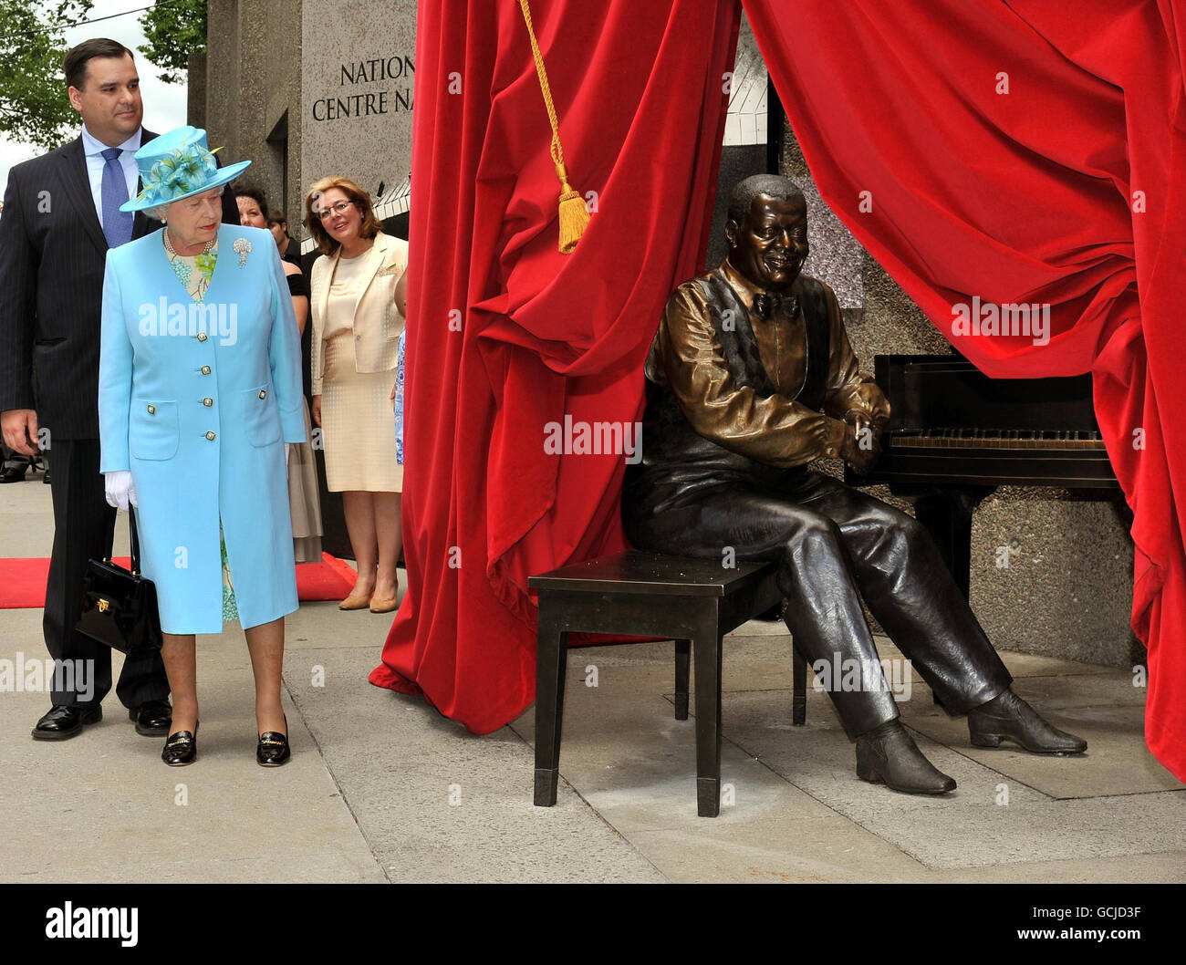 Queen Elizabeth II admires a statue of Oscar Peterson the legendary