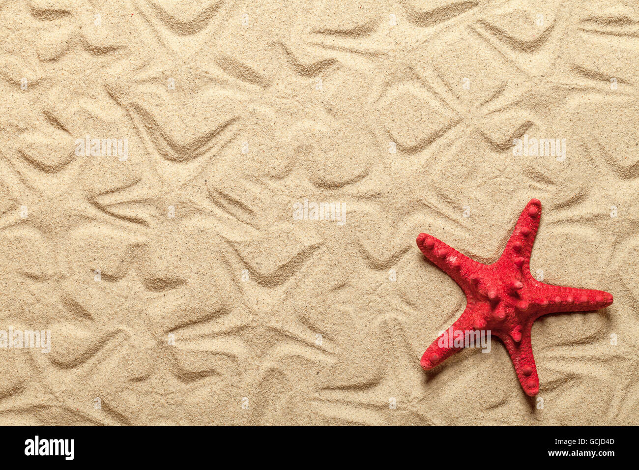 Starfish patterns with red starfish on sandy beach for background Stock Photo