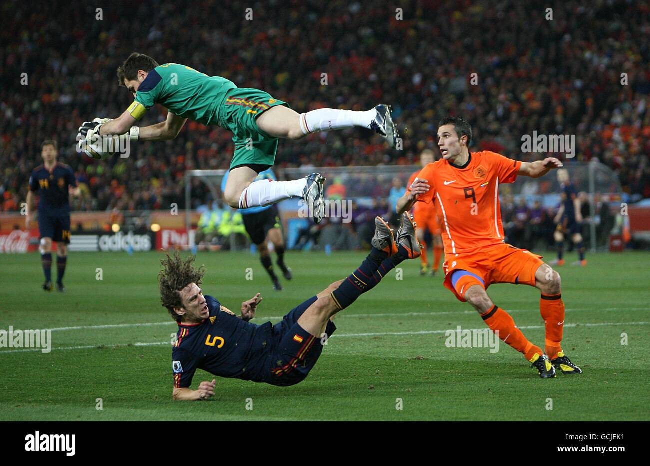 Spain goalkeeper Iker Casillas claims the ball in the air from Netherlands' Robin van Persie (right) as Spain's Carles Puyol (bottom) falls to the ground Stock Photo