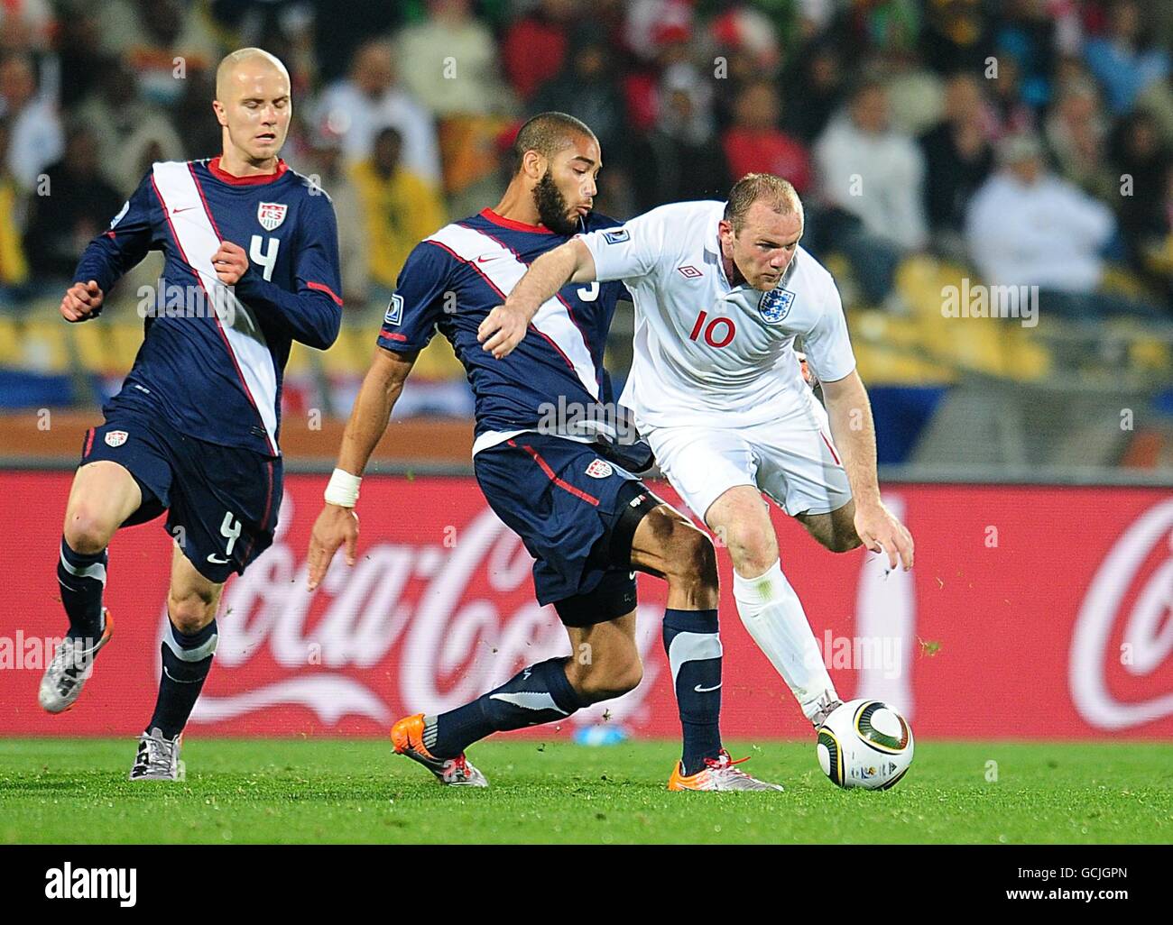 Soccer - 2010 FIFA World Cup South Africa - Group C - England v USA - Royal Bafokeng Stadium. USA's Oguchi Onyewu and England's Wayne Rooney (right) battle for the ball Stock Photo