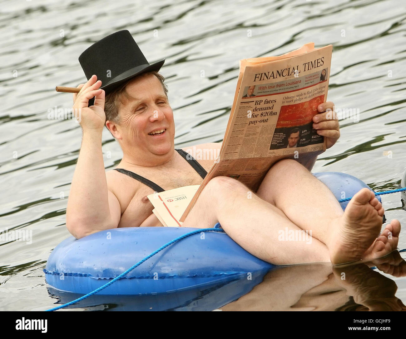 A businessman dressed in a mankini floats on a rubber ring on the Serpentine in Hyde Park, central London, during a photocall for new 'community led' mobile phone company giffgaff. Stock Photo