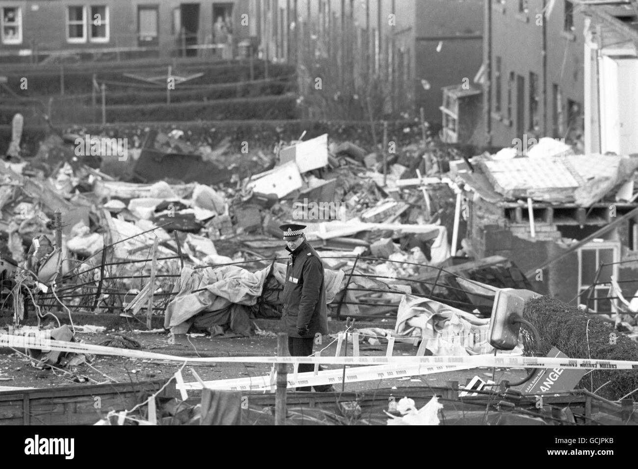 A policeman stands guard over houses damaged in the Pan Am Boeing 747 Lockerbie crash, which killed all 258 on board and 17 people on the ground. Stock Photo