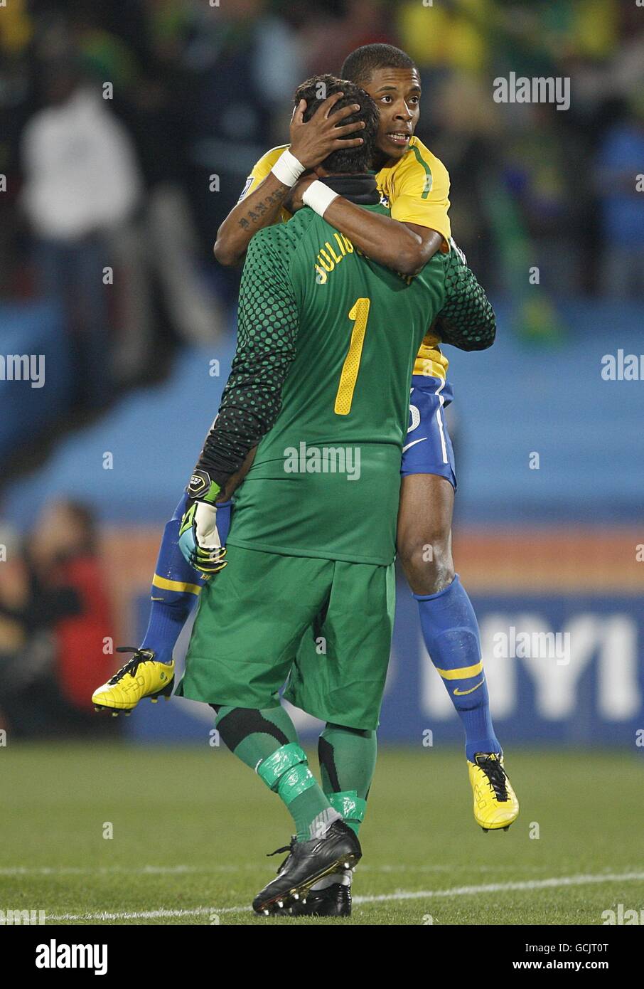 Brazil's Fernandes Michel Bastos jumps up onto his goalkeeper Soares Julio Cesar in celebration after their team mate Clemente Luis Fabiano scored their second goal. Stock Photo