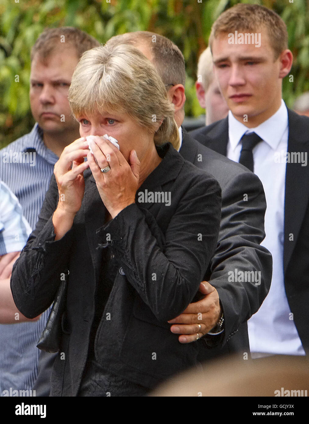 Parents Jenny and Robin (obscured) Hollington with sons Nick (not in frame) and Charlie (right) at the funeral of their eldest son, Royal Marine Richard Hollington in the village of Steep in Hampshire. The 23 year old was the 300th soldier to die in the Afghanistan conflict. He passed away on Father's Day at Queen Elizabeth Hospital in Birmingham, eight days after being wounded on patrol in Sangin Province while serving with 40 Commando. Stock Photo