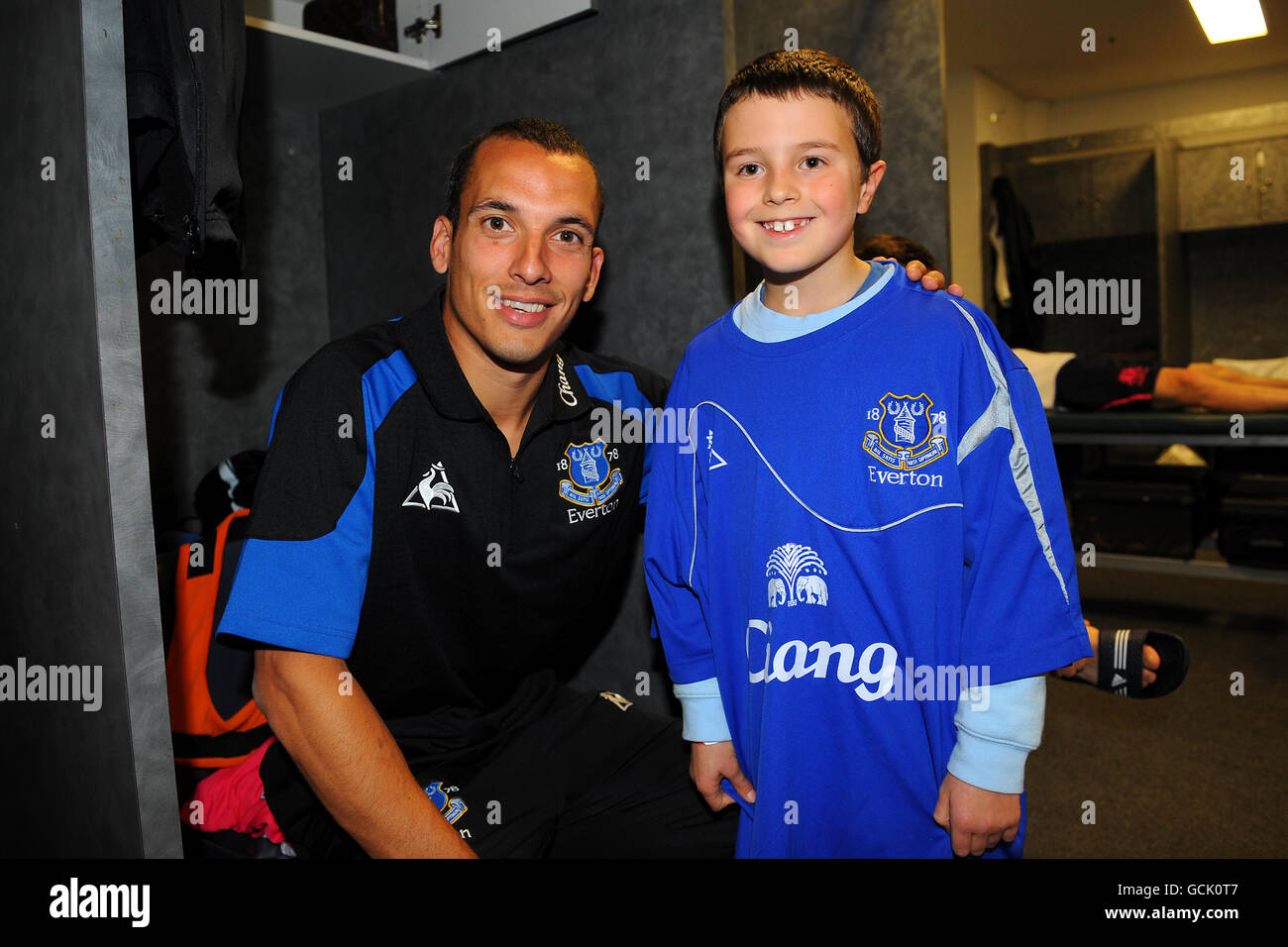 Everton's Leon Osman (l) greets a competition winner in the dressing
