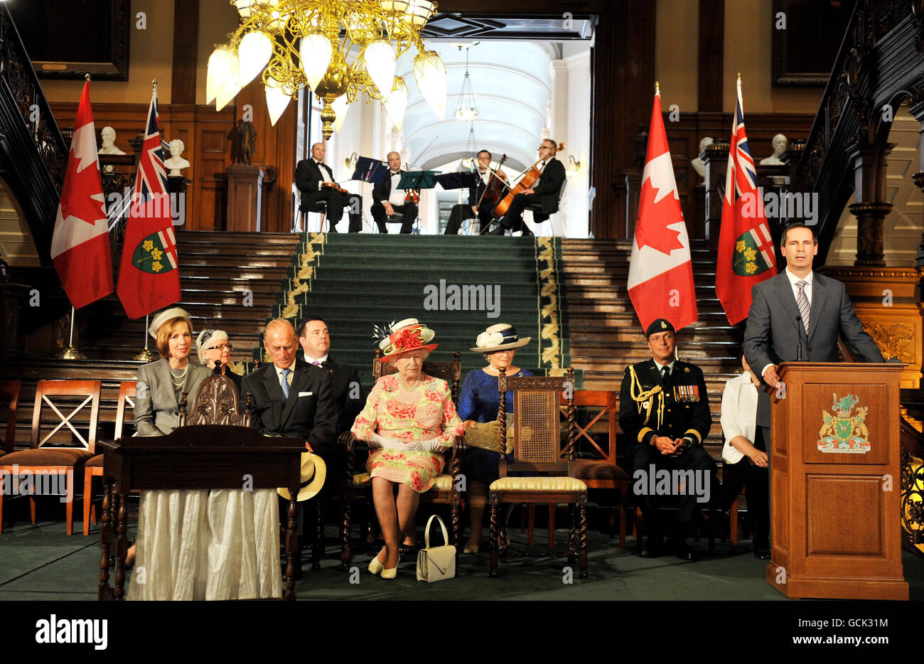 Queen Elizabeth II and the Duke of Edinburgh sit together as Dalton McGuinty (right), the Premier of Ontario, addresses them in Toronto, Canada. Stock Photo
