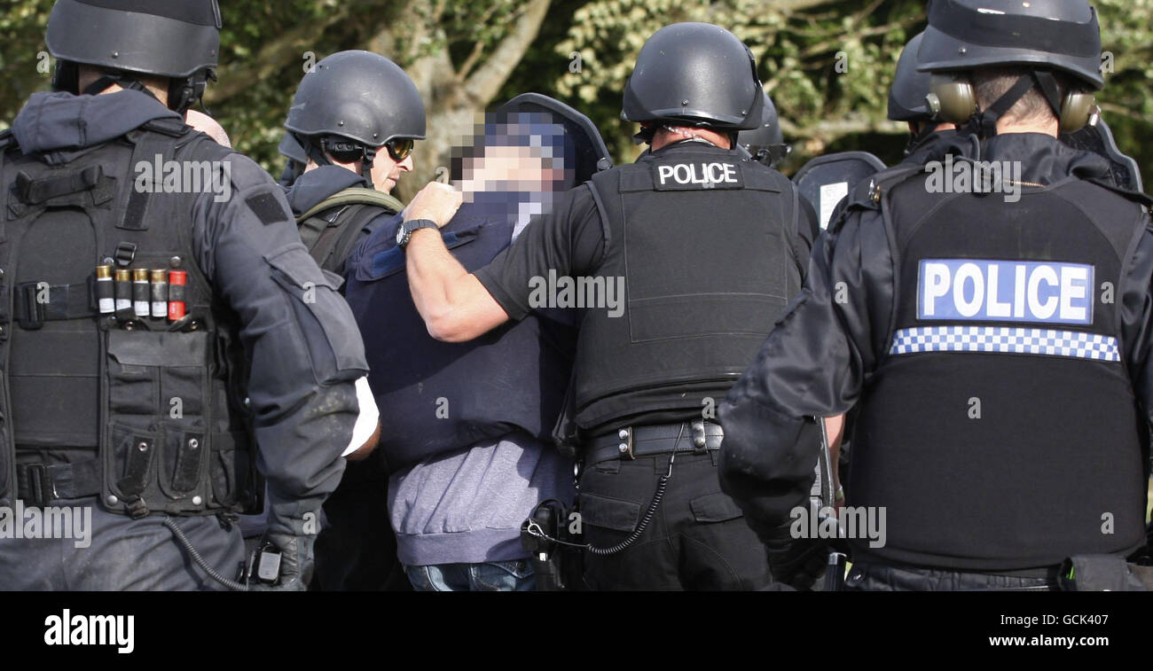 PLEASE NOTE: DETAILS HAVE BEEN PIXELATED BY THE PRESS ASSOCIATION AT THE REQUEST OF THE POLICE Armed police surround a man as they escort him near to Wagtail Farm, Northumberland, as the manhunt for fugitive gunman Raoul Moat continues. Stock Photo