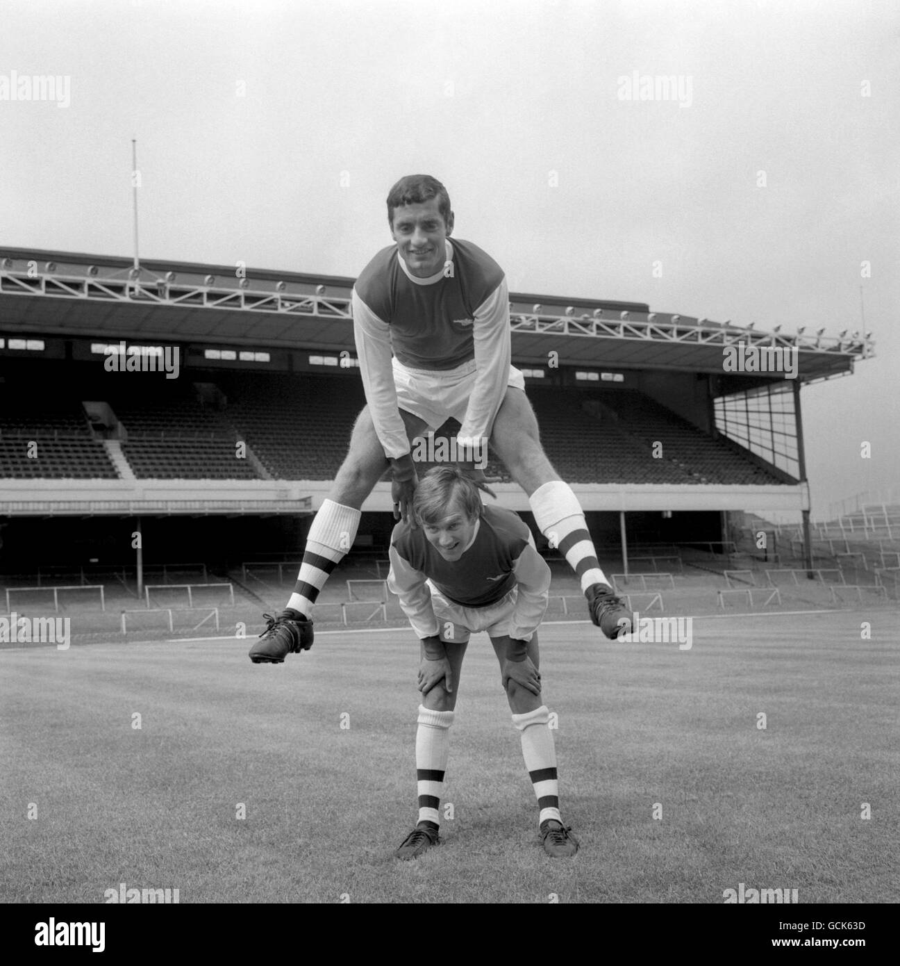 George Johnston, Glasgow born inside-forward, makes a back for leapfrogging Scottish half-back Frank McLintock today at Highbury, London, where Arsenal players were training for the forthcoming soccer season. Stock Photo