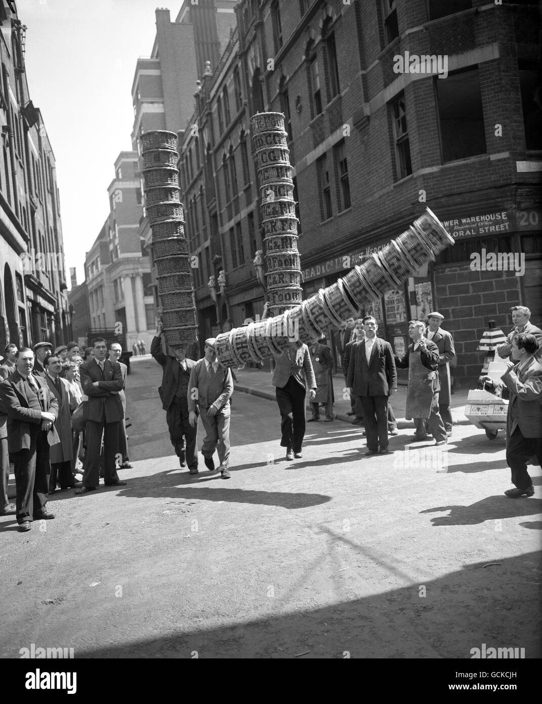 Covent Garden porters Edward White, left, Albert Bailey, centre, and Johnny Hopkins practice for the basket race to be held at the Covent Garden Market Show. Traditionally Covent Garden Market porters carry baskets tower-style on their heads. Stock Photo