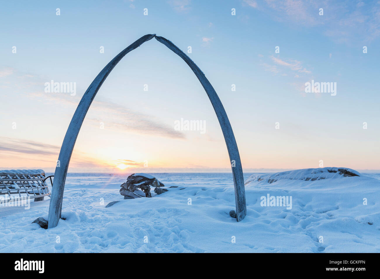 Whalebone arch frames the setting sun at the shore of the Arctic Ocean in Barrow, North Slope