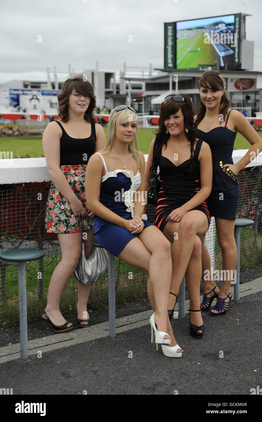Racegoers (left to right) Siobhan Mundy, (Milton Keynes, England), Molly Nightingale, (Gort, County Galway), Lucy Robinson (Kinvara, Galway) and Helen Fahy (Gort, County Galway) on day four of the Summer Festival at Galway Racecourse, Ireland. Stock Photo