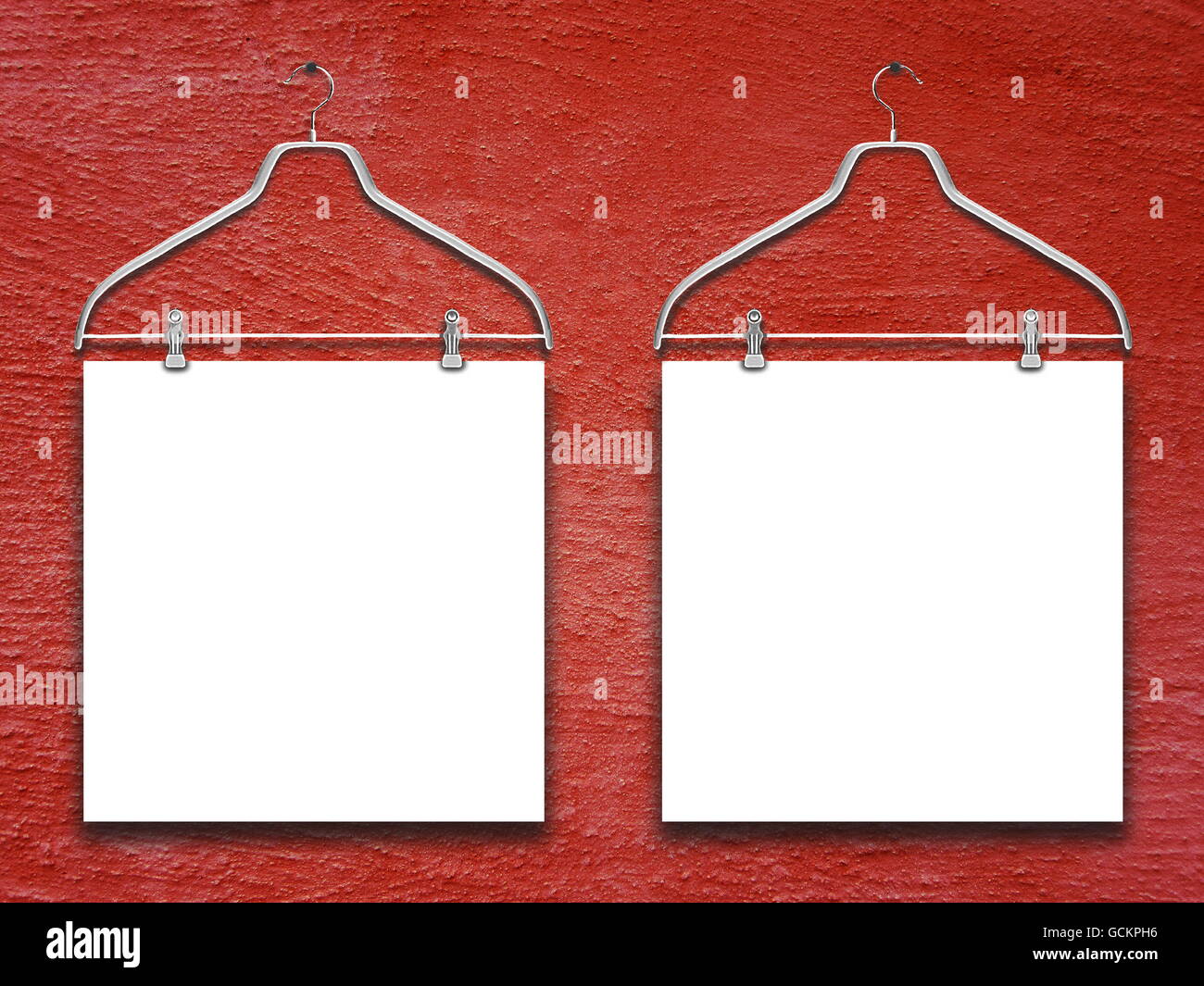 Close-up of two square blank frames hanged by clothes hanger against red rough concrete wall background Stock Photo