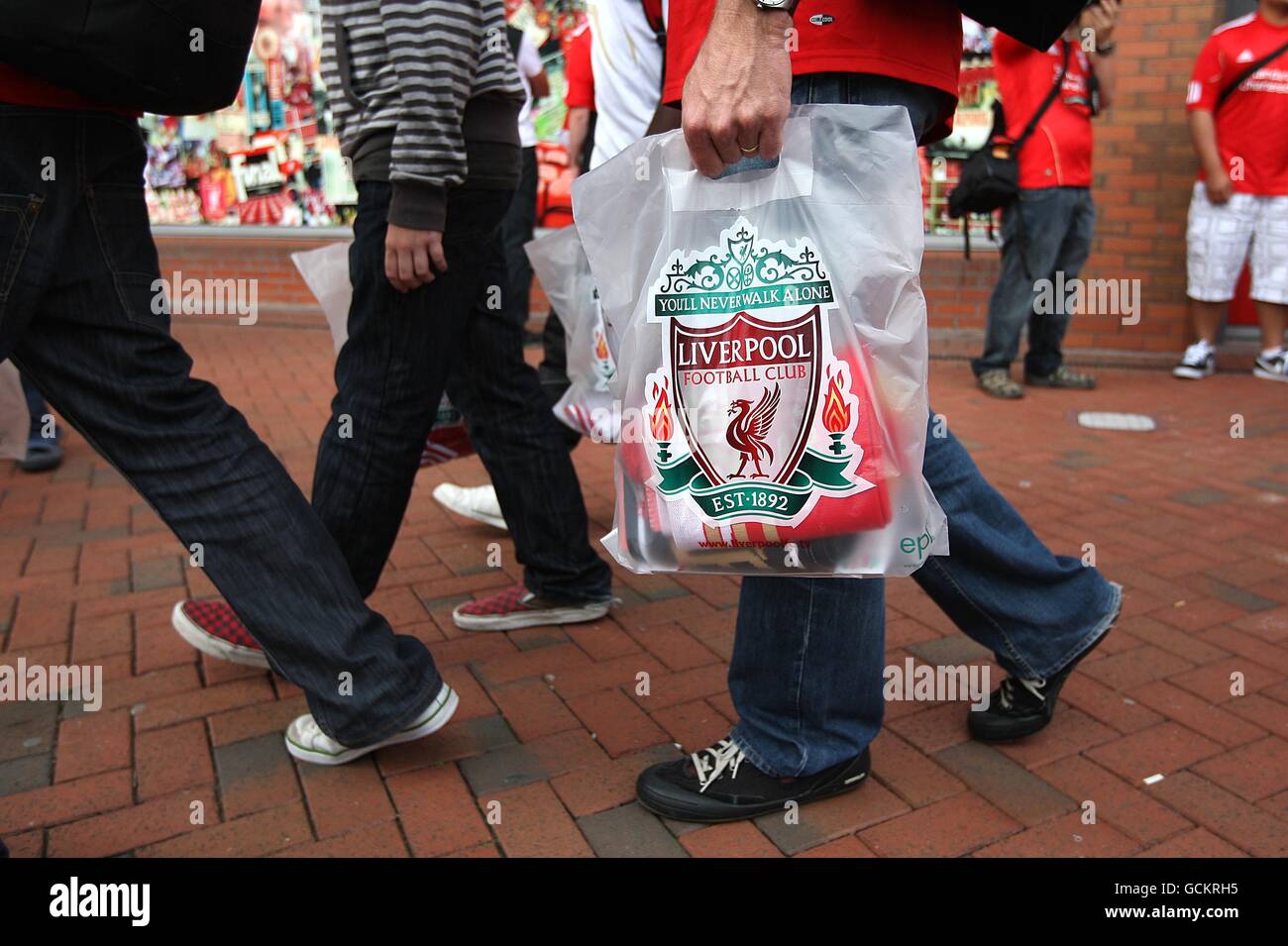A Liverpool fan carries a bag after visiting the Liverpool FC Club Shop Stock Photo