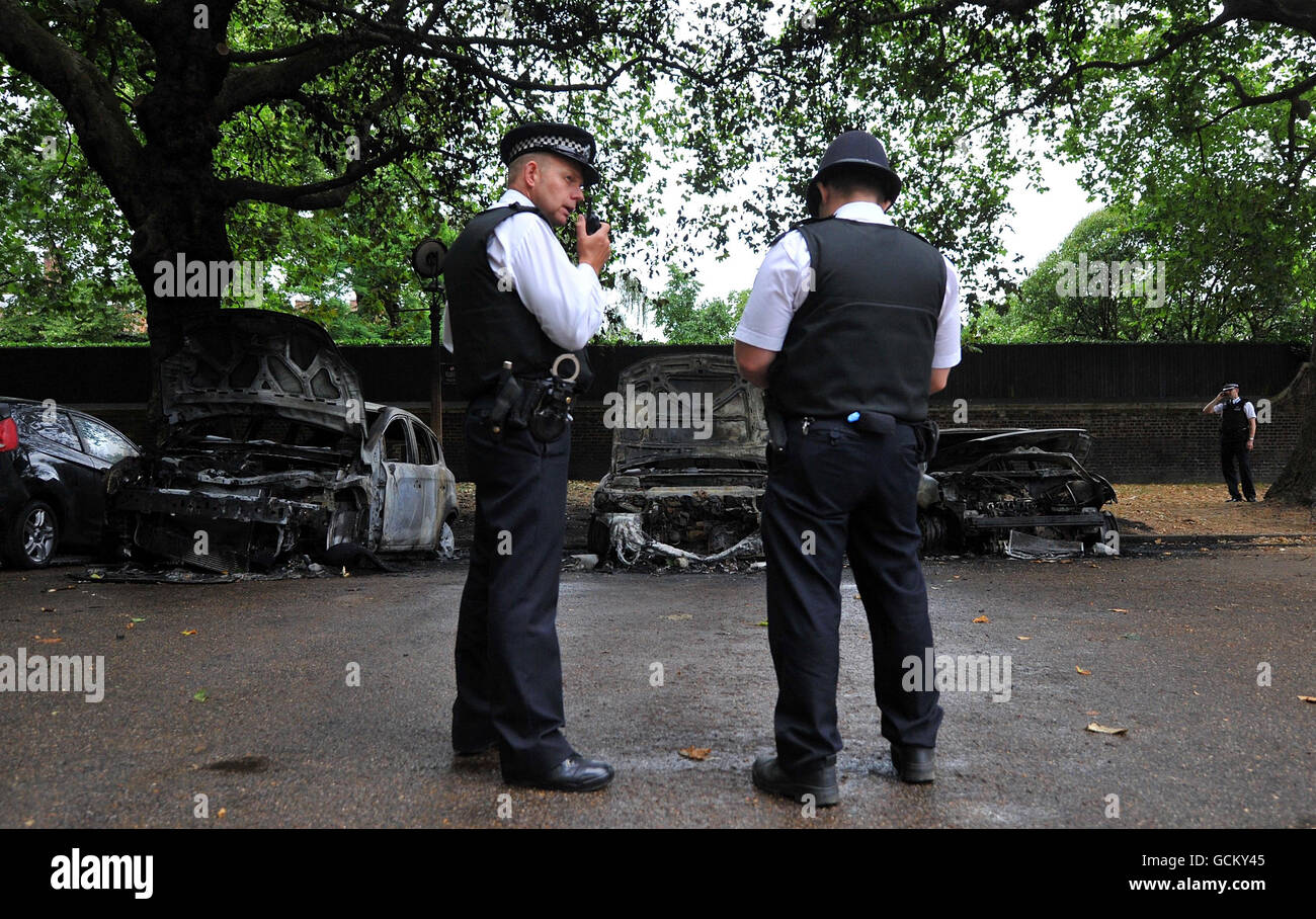 Police officers stand next to the wreckage of three cars after they caught fire on The Mall near Clarence House in central London. Stock Photo