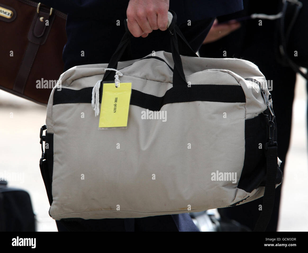 Luggage with a label reading 'The Queen' is carried onboard the