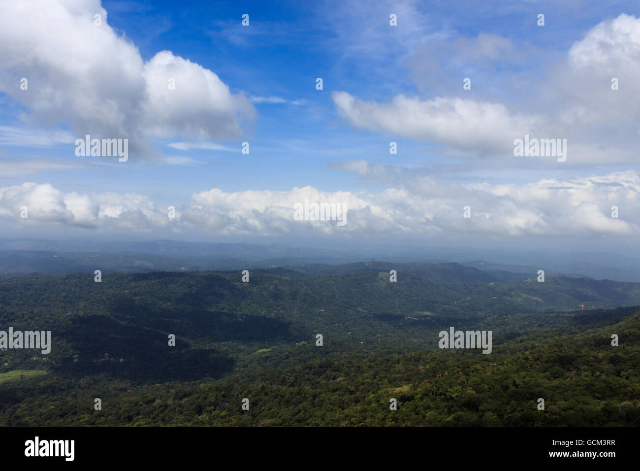 White Clouds Floating Above Hilly Terrain Stock Photo