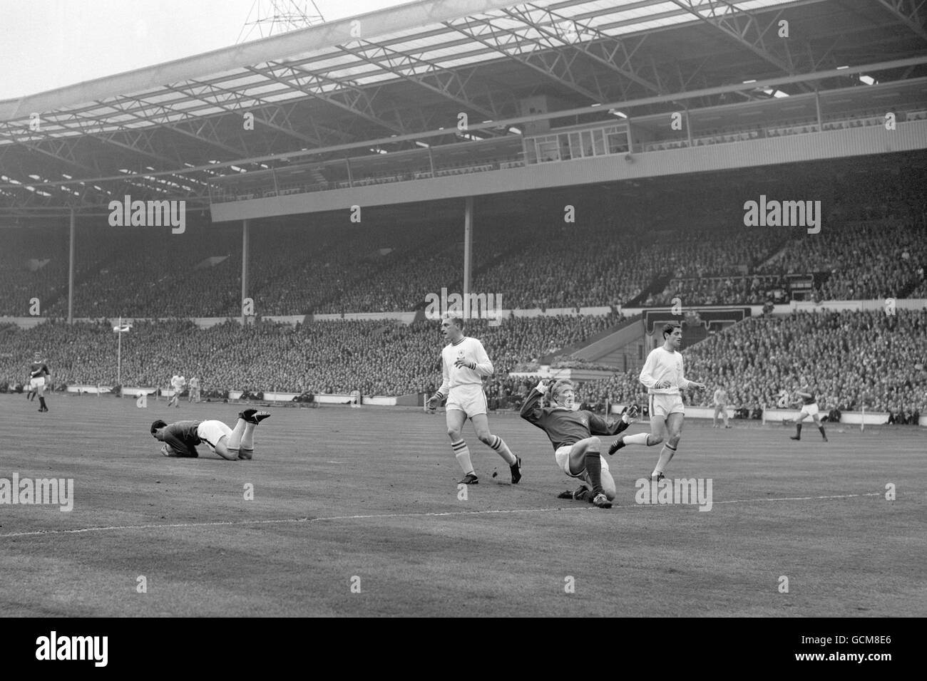 Manchester United's Denis Law, second right, slides on one knee as Leicester City goalkeeper Gordon Banks pounces on the ball. Leicester City defenders are Richie Norman, second left, and Frank McLintock, right. Stock Photo