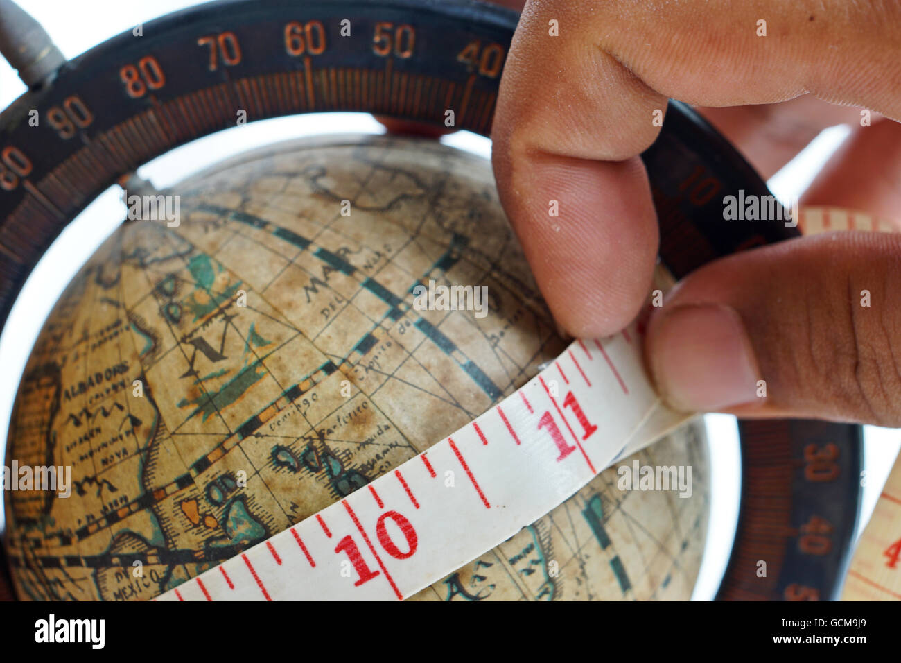 close up of vintage global map with measuring tape around Stock Photo