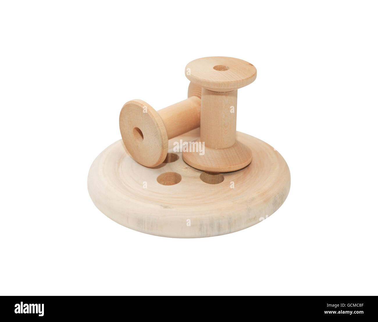 Sewing concept. Two empty wooden spools on big button.  Isolated on white background with clipping path Stock Photo