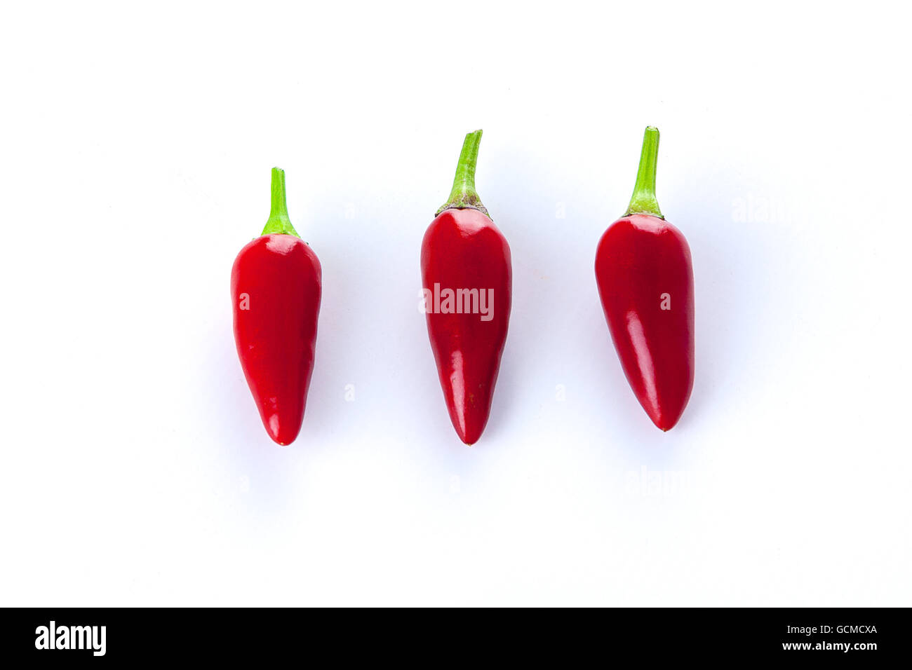 Group of three red chili peppers in a row Stock Photo Alamy