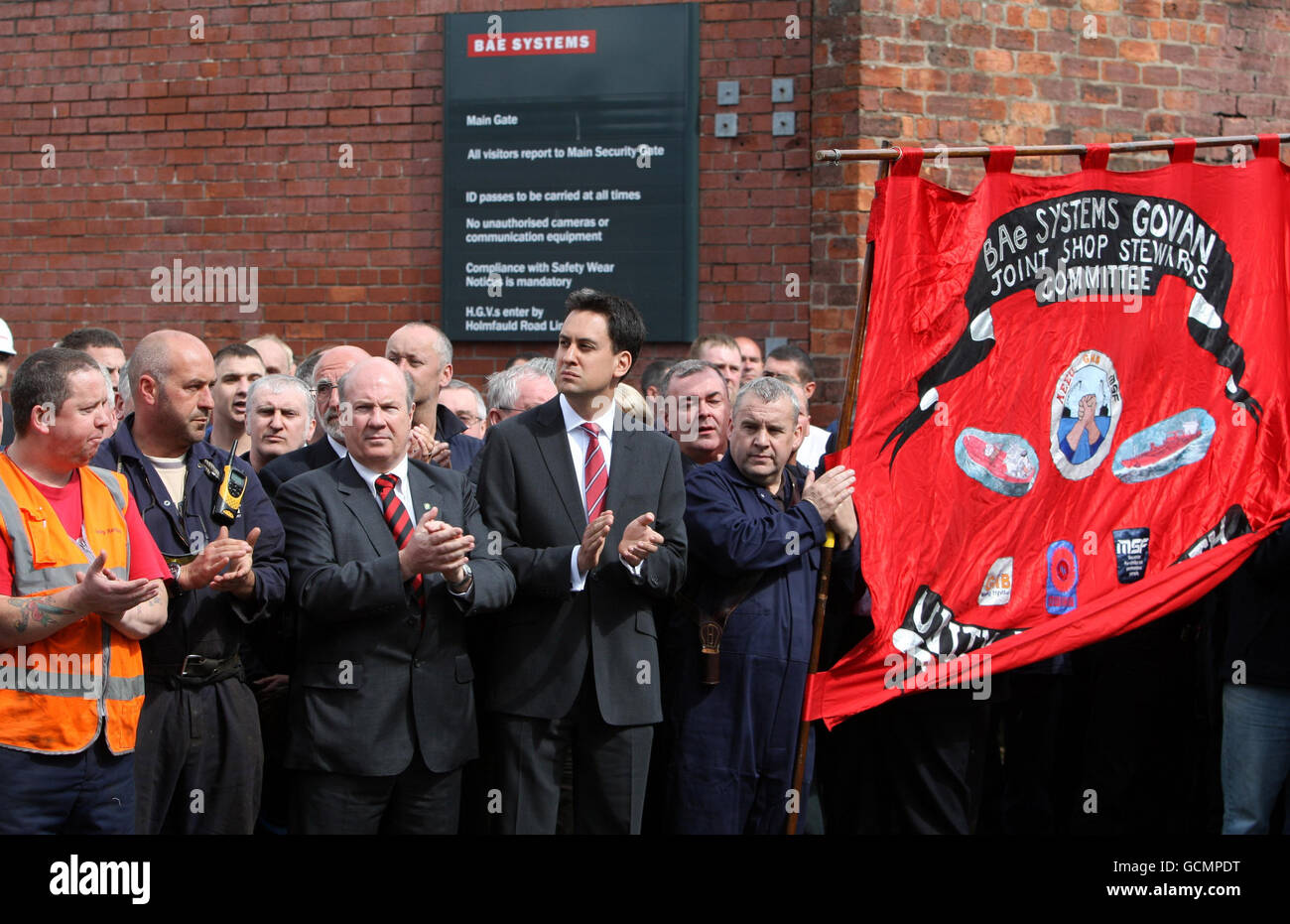 Ed Miliband (centre) as the coffin of former Glasgow shipyard union leader Jimmy Reid passes workers who lined the streets outside Govan Ship yard on its way to Govan Old Parish Church in Glasgow for his funeral. Stock Photo