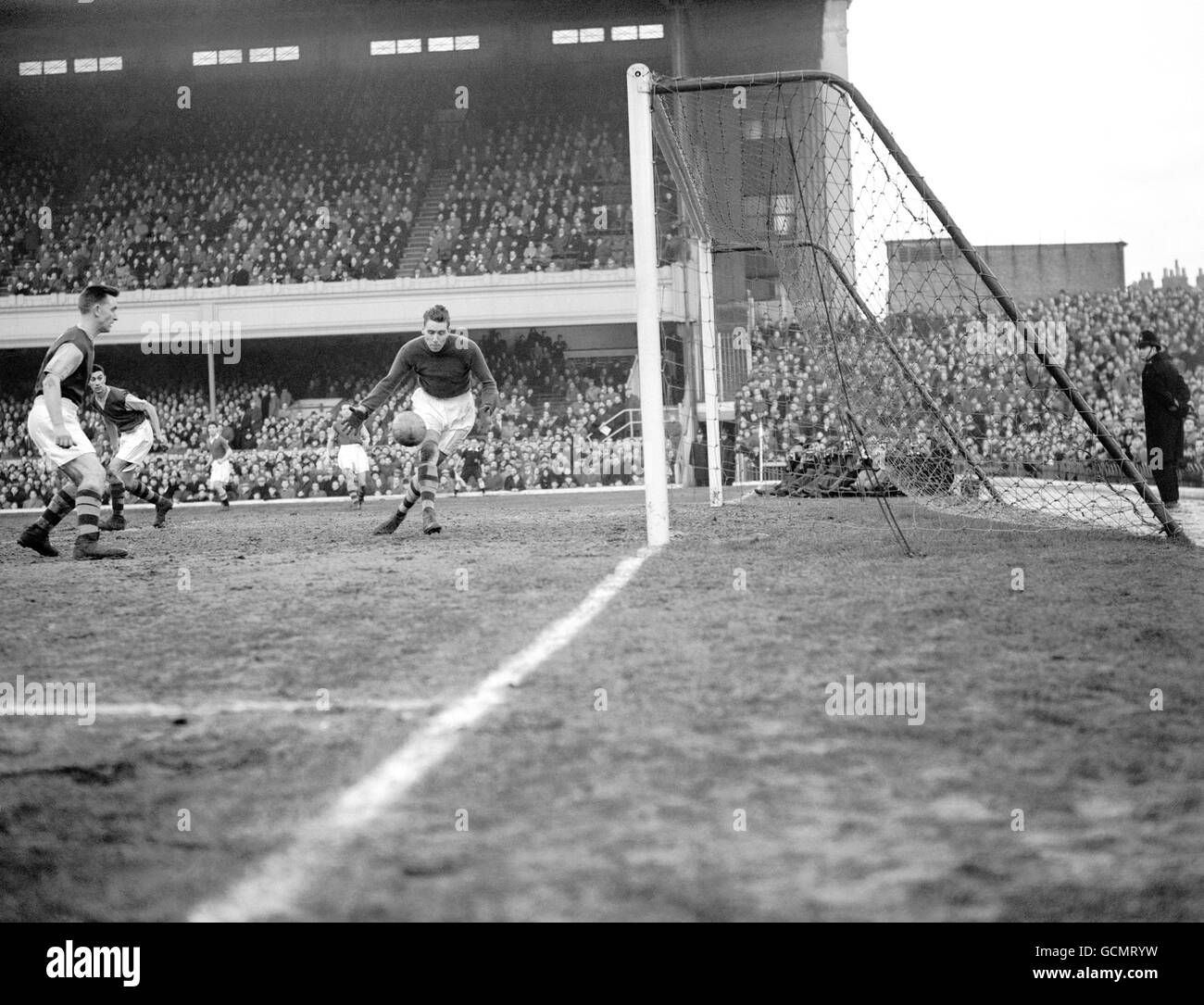 A near thing for Burnley, as McDonald the Burnley goalkeeper is beaten by a shot from Saunders the Chelsea left half, which hit the post and rebound into play. Stock Photo