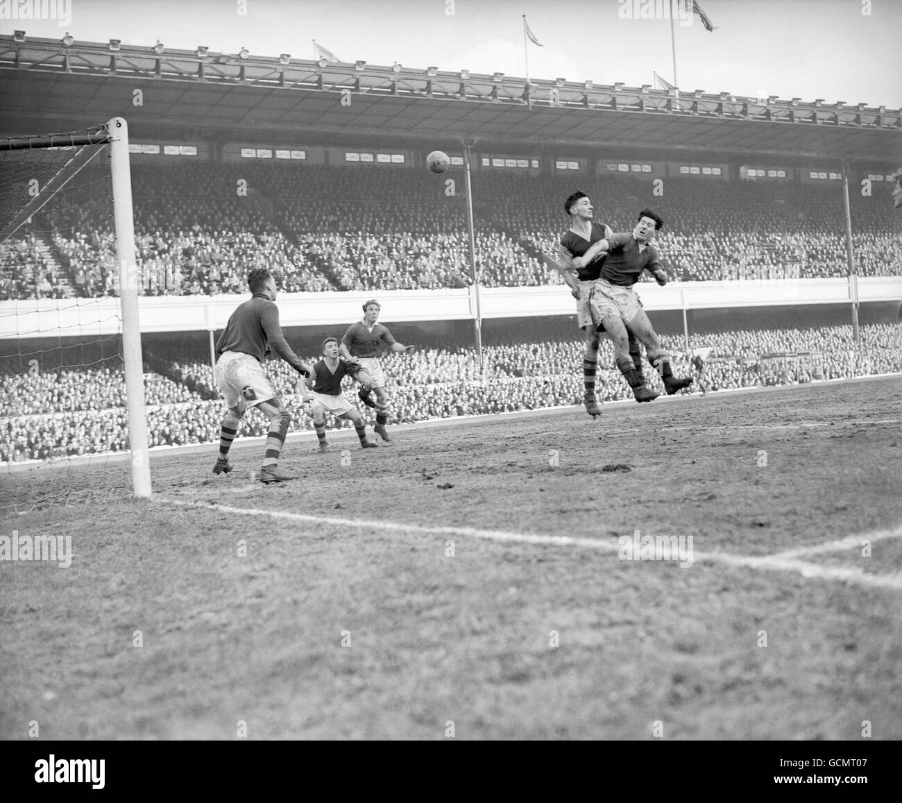 In the Burnley goal area, McNichol (Chelsea) and Adamson the Burnley center half, both go for the ball in the air, watched by McDonald the Burnley goalkeeper. Stock Photo