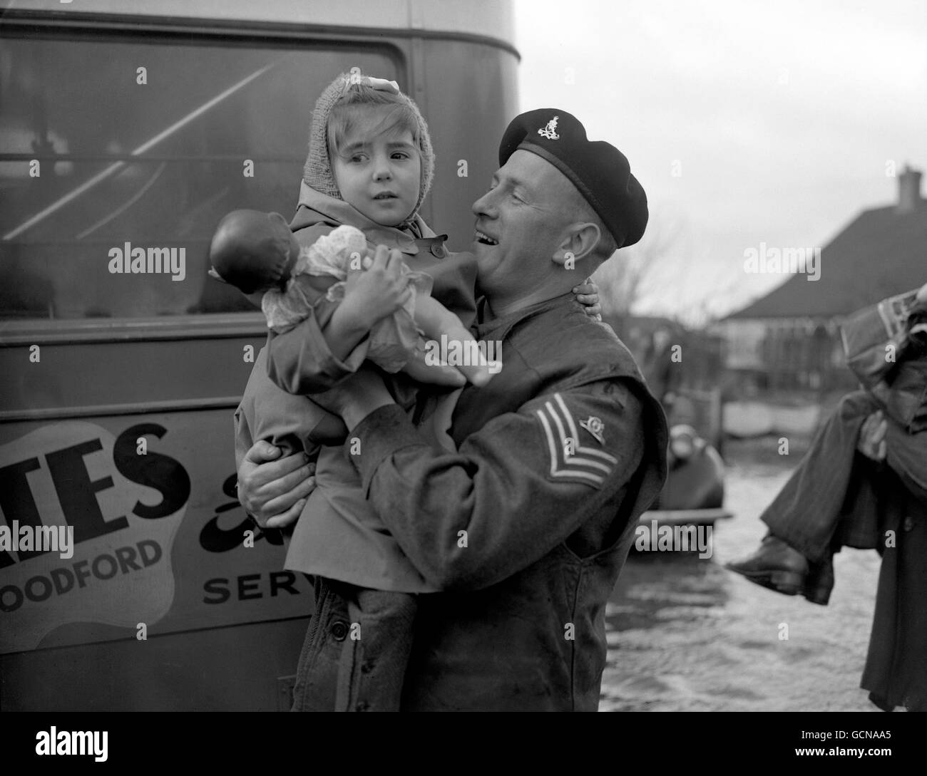A Royal Artillery sergeant carries a small evacuee, who remembered her doll, to an evacuation bus. The last 2,000 inhabitants were compulsorily evacuated by police, troops and other services from Canvey Island, Essex, where more than 100 people are known to have died in the flood disaster. About 500 people are missing. Stock Photo