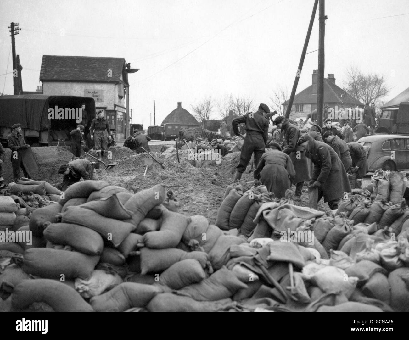 Servicemen and civilian workers are toiling at Canvey Island, Essex, to repair the sea defences, damage to which caused the disastrous floods which cost many lives on the island and rendered thousands homeless. Stock Photo