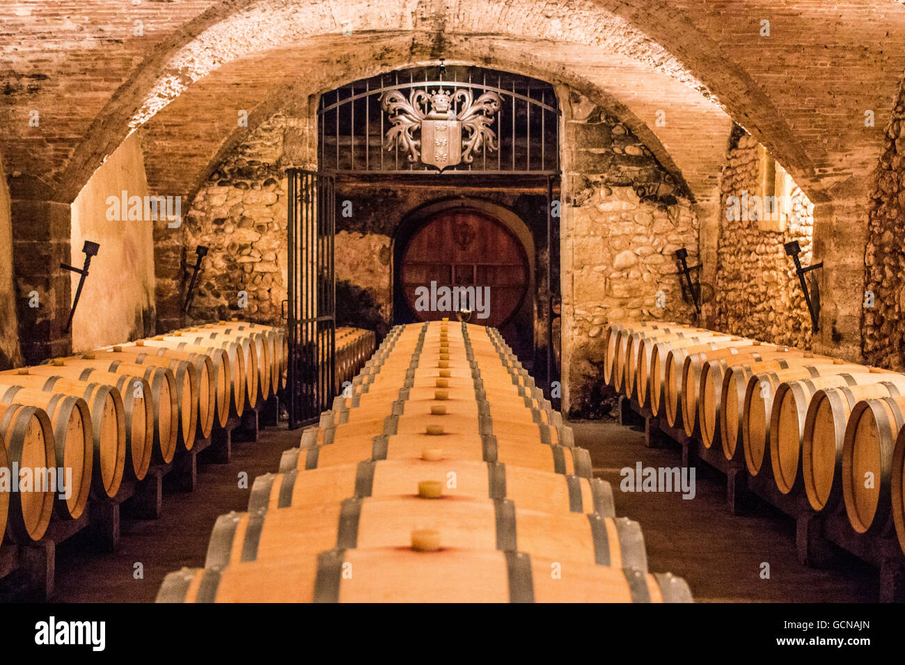 Winery cellar with special edition wine waiting in barrels for a few years until it is ready at Chateau la Nerthe. Stock Photo