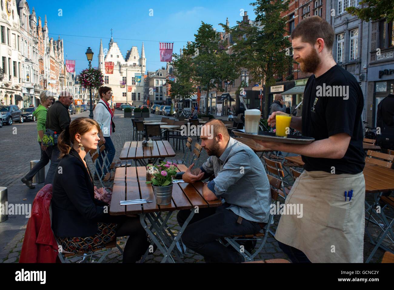 Bars and restaurants in IJzerenleen street, Mechelen (Malines) at sunset, Flanders, Belgium. IJzerenleen street or square with t Stock Photo