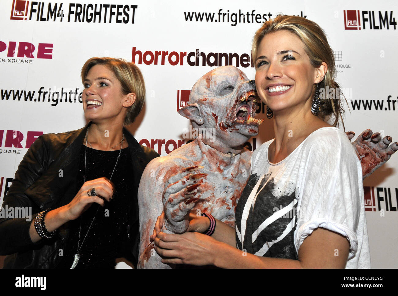 Gemma Atkinson (right) and Isabella Calthorpe pose with a werewolf to promote new British horror film 13 hrs which premiered at the Empire Cinema in Leicester Square, London, as part of Film 4's Frightfest horror movie festival. Stock Photo