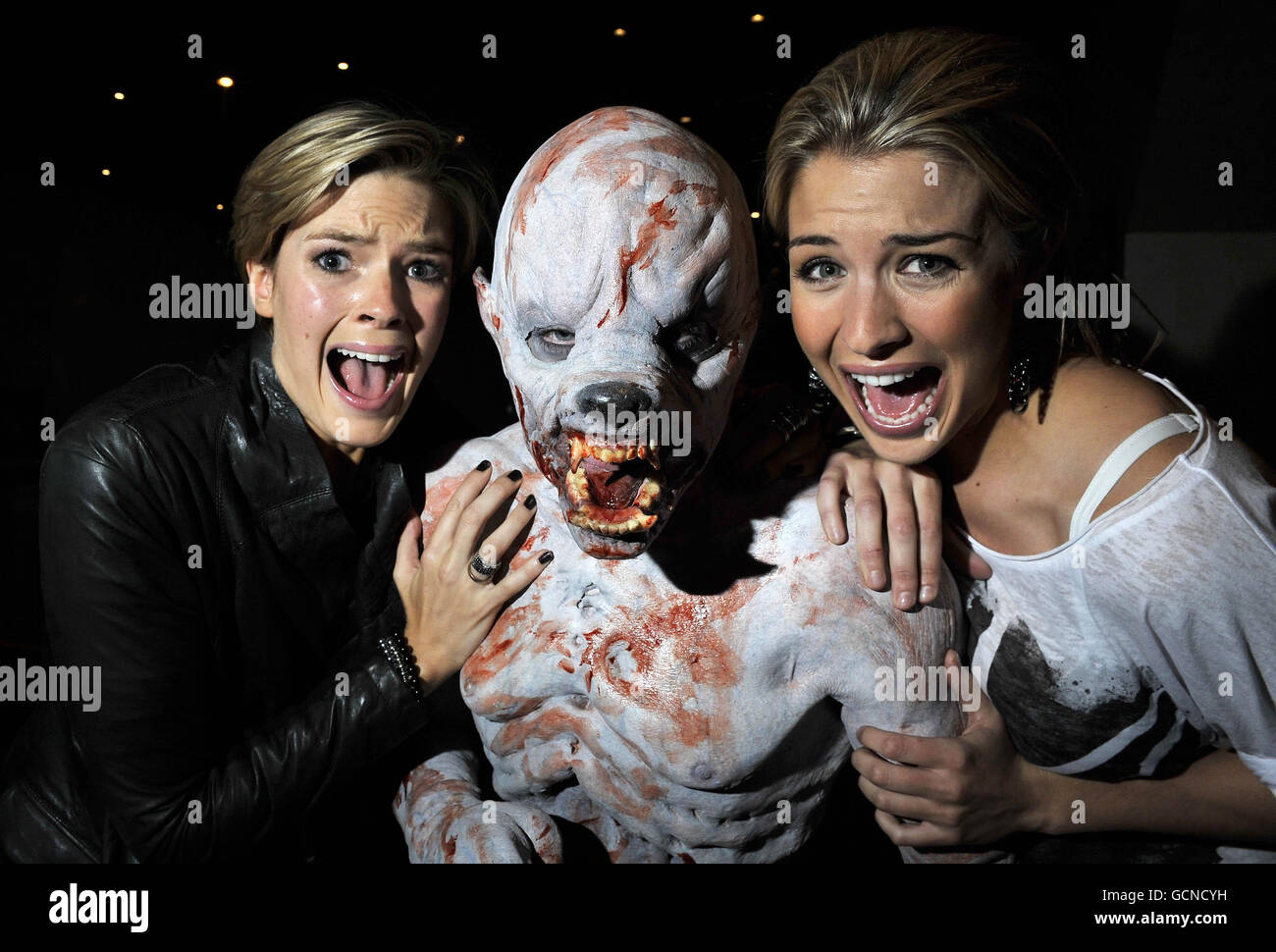 Gemma Atkinson (right) and Isabella Calthorpe pose with a werewolf to promote new British horror film 13 hrs which premiered at the Empire Cinema in Leicester Square, London, as part of Film 4's Frightfest horror movie festival. Stock Photo