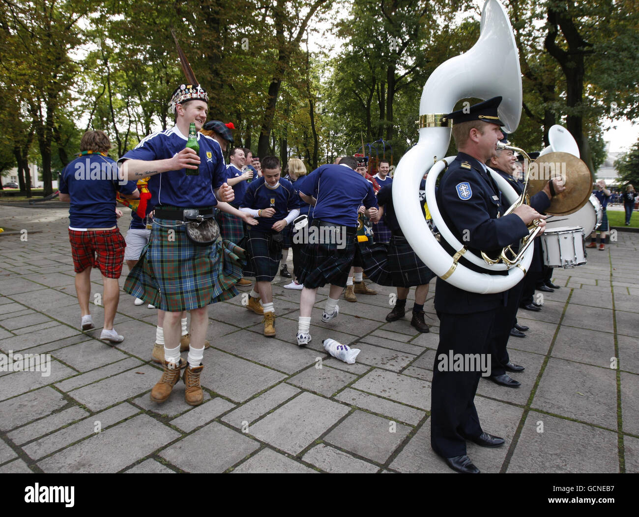 Scottish football fans having fun in the centre of Kaunas as a local Lithunania brass band play in the streets ahead of the UEFA European Championship Qualifing match at the Darius Girenas Stadium, Kaunas. Stock Photo